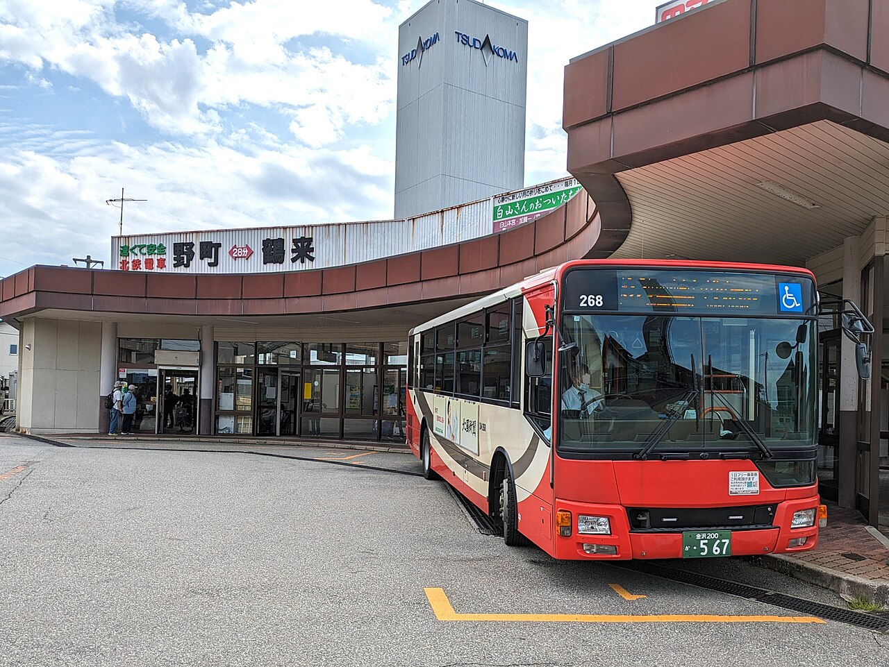 A cream and red Hokutetsu city bus at Nomachi Station